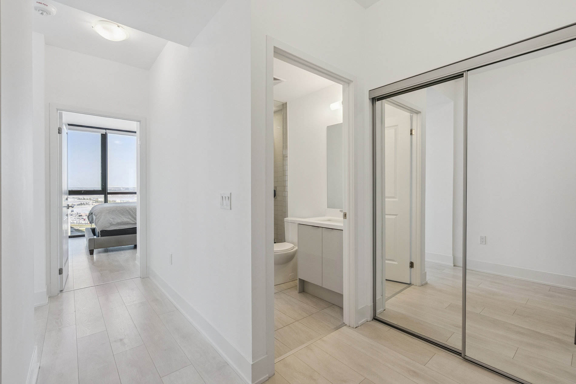Hallway with bedroom view and mirrored closet